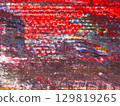 Vibrant abstract artwork featuring bold colors and intricate textures created by a contemporary artist in a studio setting 129819265