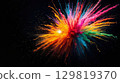 A vibrant burst of colored powder spreads across a dark backdrop, creating a captivating display of hues. This mesmerizing spectacle showcases a joyful celebration of color and energy 129819370