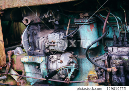 Old agricultural engine showing signs of wear and rust with intricate mechanics captured in natural light Old agricultural engine showing signs of wear and rust with intricate mechanics captured in natural light 129819755