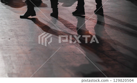 Legs and shadows of people walking on a sidewalk 129820504