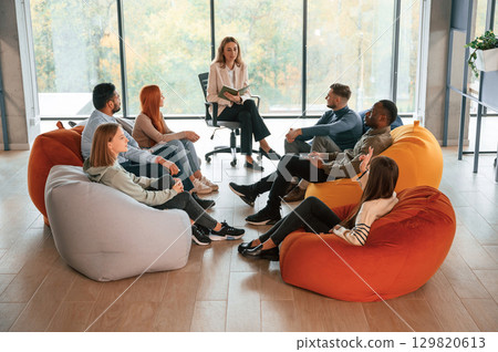 Sitting at the circle. Group of people are having therapy meeting together 129820613