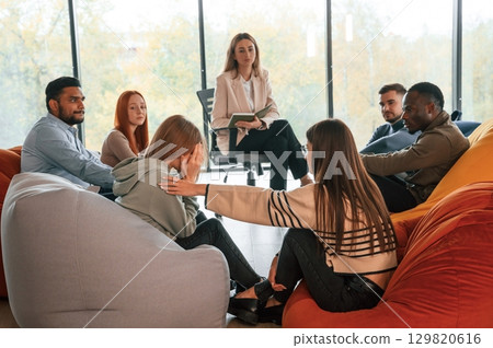 Sitting at the circle. Group of people are having therapy meeting together Sitting at the circle. Group of people are having therapy meeting together 129820616