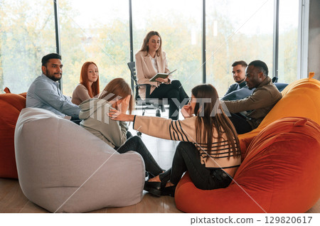 Sitting at the circle. Group of people are having therapy meeting together 129820617