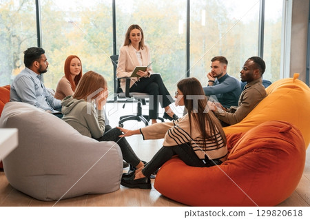 Sitting at the circle. Group of people are having therapy meeting together 129820618