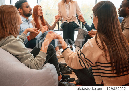 Holding hands. Group of people are having therapy meeting together 129820622
