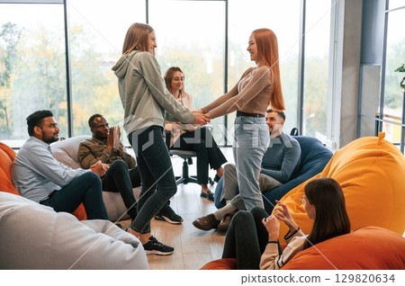 Women are greeting and support each other. Group of people are having therapy meeting together 129820634
