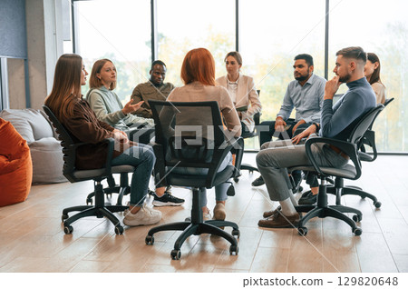 On the chairs. Group of people are having therapy meeting together On the chairs. Group of people are having therapy meeting together 129820648