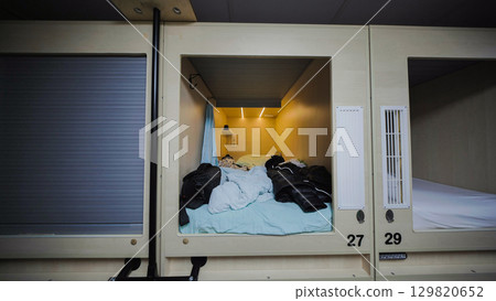 Capsule hotel room offering privacy and comfort for travelers 129820652