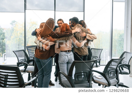 Embracing each other. Group of people are having therapy meeting together 129820688