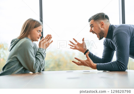 Side view, near big window. Man is screaming at his girlfriend, conception of quarrel 129820798