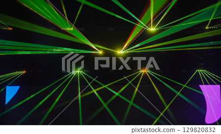 Green laser lights illuminating dark concert hall during music show 129820832