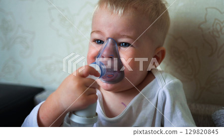 The kid breathes funny and plays with a medical inhaler. The kid breathes funny and plays with a medical inhaler. 129820845