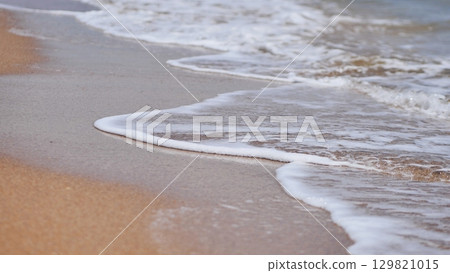 Soft wave gently washing Crimean sandy beach in summer Soft wave gently washing Crimean sandy beach in summer 129821015