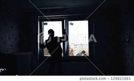 Silhouettes of builders install plastic windows in the house. 129821081