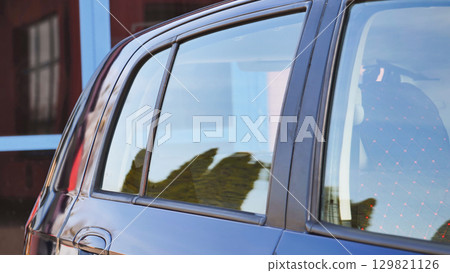 Clean car reflecting building and trees after car wash 129821126