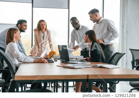 On the meeting, discussing the plans. Group of office workers are together indoors On the meeting, discussing the plans. Group of office workers are together indoors 129821208