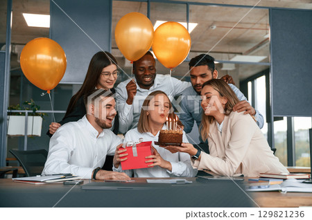 Cake with candles. Employee having a birthday in the office, group of workers 129821236