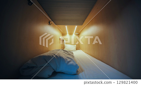Empty capsule hotel room inviting guests for comfortable overnight stay 129821400