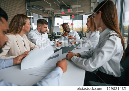 Brainstorming, holding documents, thinking. Group of office workers are together indoors 129821485