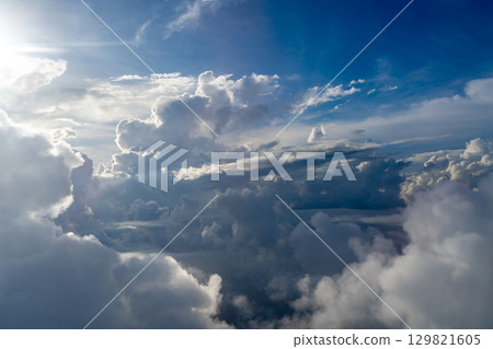 Dramatic sky with sunbeams and clouds seen from an airplane Dramatic sky with sunbeams and clouds seen from an airplane 129821605