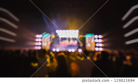 Crowd enjoying live music concert with bright colorful stage lights, blurred defocused bokeh background Crowd enjoying live music concert with bright colorful stage lights, blurred defocused bokeh background 129821694