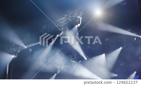 Professional lighting equipment illuminating stage with beams of light during a show Professional lighting equipment illuminating stage with beams of light during a show 129822237