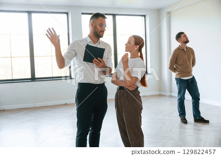 Realtor shows an apartment to a young couple Realtor shows an apartment to a young couple 129822457