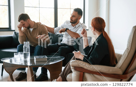 Man is feeling bad, crying. Gay couple at a psychologist's appointment 129822774