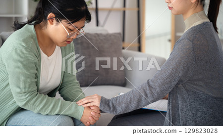 Psychologist or family holding hands to encourage patient with depression, mental health concept Psychologist or family holding hands to encourage patient with depression, mental health concept 129823028