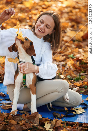 Woman is with her cute dog in the autumn forest Woman is with her cute dog in the autumn forest 129823270