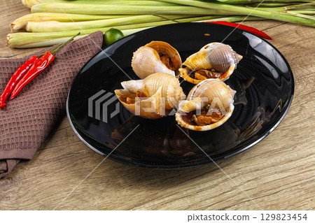 Snails baked with garlic and spices 129823454