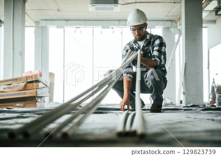 Construction worker in uniform in empty unfinished room 129823739