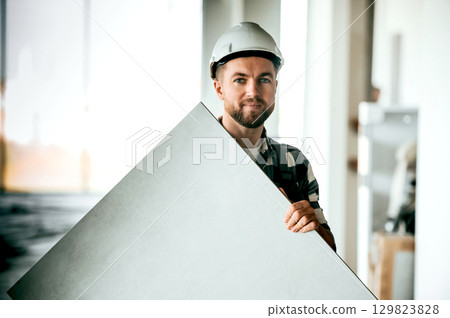 Repairman in uniform is in the unfinished building Repairman in uniform is in the unfinished building 129823828