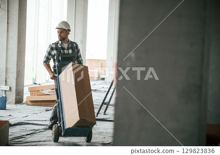 Repairman in uniform is in the unfinished building Repairman in uniform is in the unfinished building 129823836