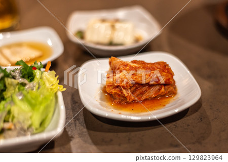 A plate of kimchi served with side dishes including tofu and salad, Korean food 129823964