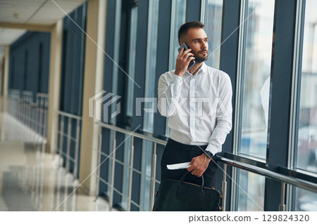 Talking by phone. Young handsome man in the airport Talking by phone. Young handsome man in the airport 129824320