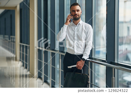 Talking by phone. Young handsome man in the airport Talking by phone. Young handsome man in the airport 129824322
