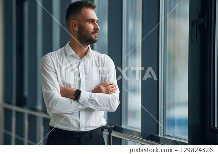 Standing with arms crossed. Young handsome man in the airport Standing with arms crossed. Young handsome man in the airport 129824326