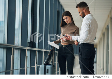 Checking the valid information. Woman is with airport worker, with tickets Checking the valid information. Woman is with airport worker, with tickets 129824357
