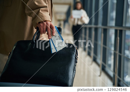 Man arrives from the flight in the airport entrance hall, woman is meeting him with name blank 129824546
