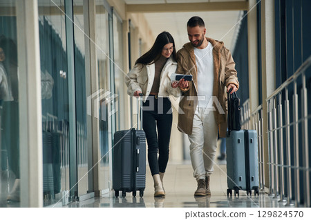 In the airport hall, walking. Couple are together In the airport hall, walking. Couple are together 129824570