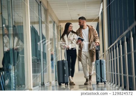 In the airport hall, walking. Couple are together In the airport hall, walking. Couple are together 129824572