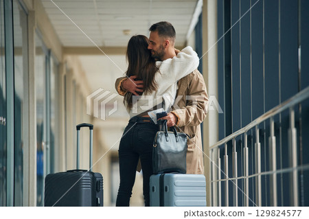 Embracing each other. Couple are in the airport hall together Embracing each other. Couple are in the airport hall together 129824577