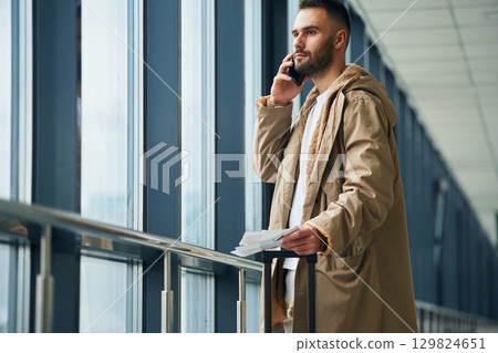 Talking by phone. Young handsome man in the airport Talking by phone. Young handsome man in the airport 129824651
