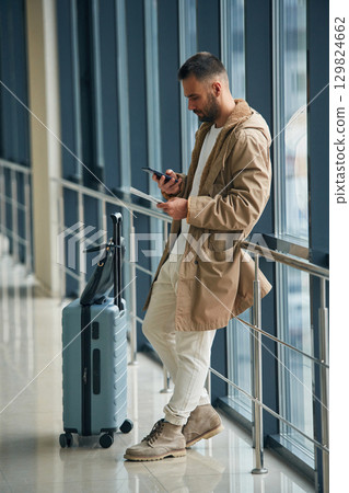 Waiting, standing inside. Young handsome man in the airport Waiting, standing inside. Young handsome man in the airport 129824662