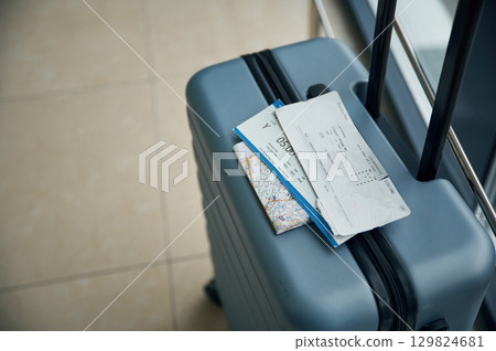 Luggage bag with tickets for flight on it, close up view Luggage bag with tickets for flight on it, close up view 129824681