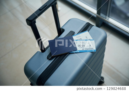 Luggage bag with tickets for flight on it, close up view 129824688