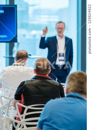 Speaker addressing audience at conference with focused attention 129824922