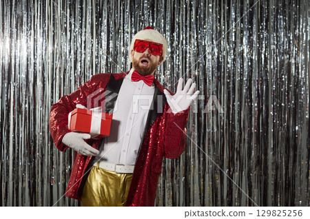 Surprised Santa Holding Gift Box At Party 129825256