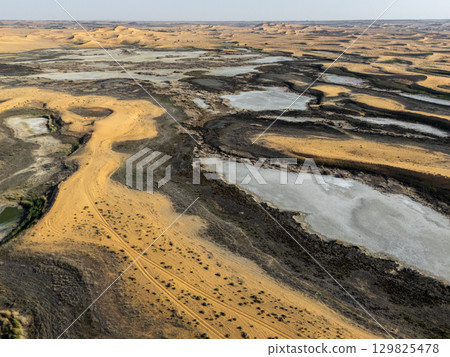 Aerial View of Desert Landscape with Sand Dunes and Salt Flats in Saudi Arabia 129825478